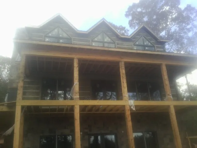 Dormers and porch framing on a large log home under construction — Roof Coating work by our crew in Hermitage